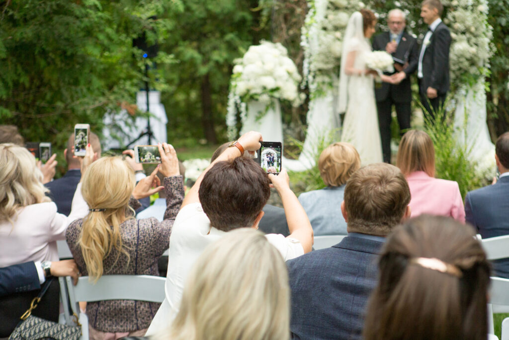People taking photos with their phones at a wedding ceremony