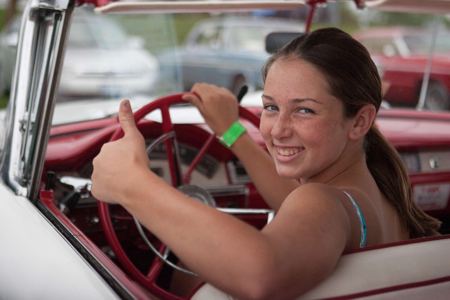 Portrait of a girl smiling in a car with natural light and shallow depth of field